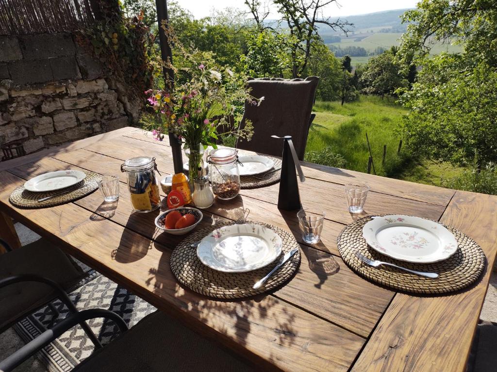 een houten tafel met borden eten erop bij Chateau d 'Impasse in Laferté-sur-Amance