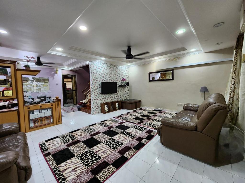 salon z kanapą, łóżkiem i telewizorem w obiekcie Homestay Taman Pauh Jaya, Seberang Perai, Bukit Mertajam w mieście Perai