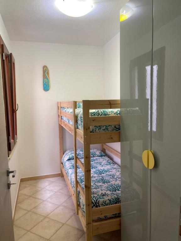 um quarto com 2 beliches e uma porta de vidro em À Grancéa em Calasetta