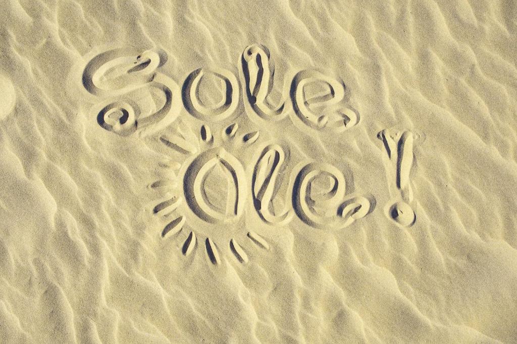 a sign in the sand with the word love glue at SoleOle in Playa de Gandia