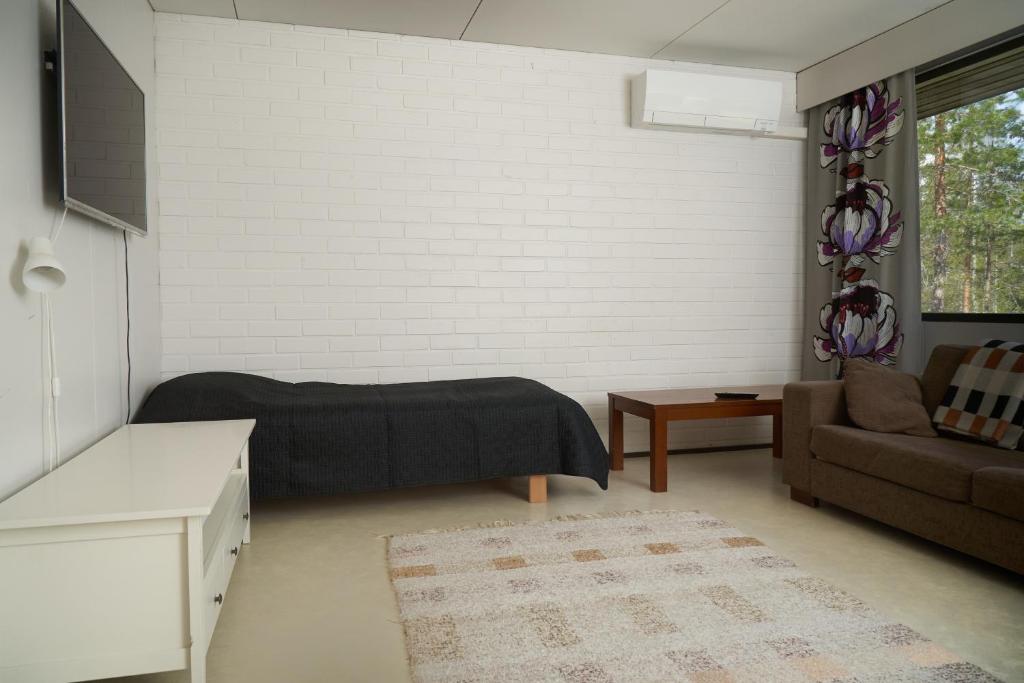 salon z łóżkiem i kanapą w obiekcie Rantasaunallinen yksiö w mieście Virrat