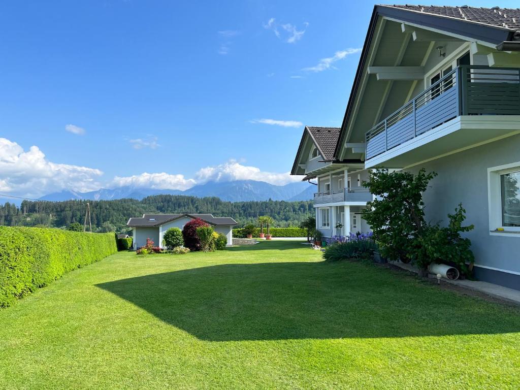 a house with a large yard with mountains in the background at Das Bergl in Rosegg