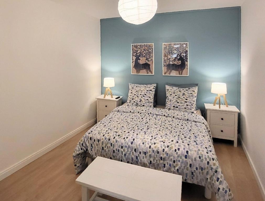 a bedroom with a bed with two night stands and two lamps at Appartement 1 Chambre, cuisine, coin salon, salle de bain in Saint-Claude