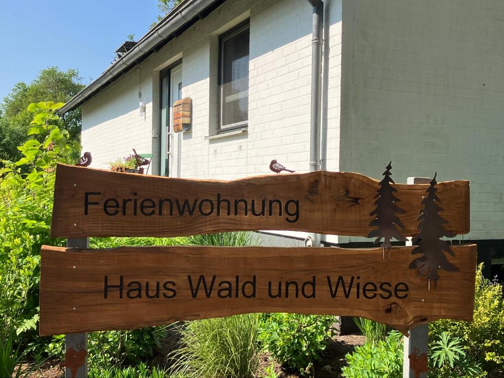 a wooden sign in front of a house at Haus Wald und Wiese Wohnung Wald in Ehndorf