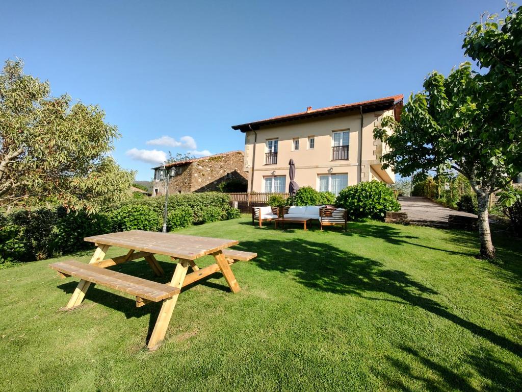 a picnic table in the yard of a house at Apartamentos Corona in Comillas