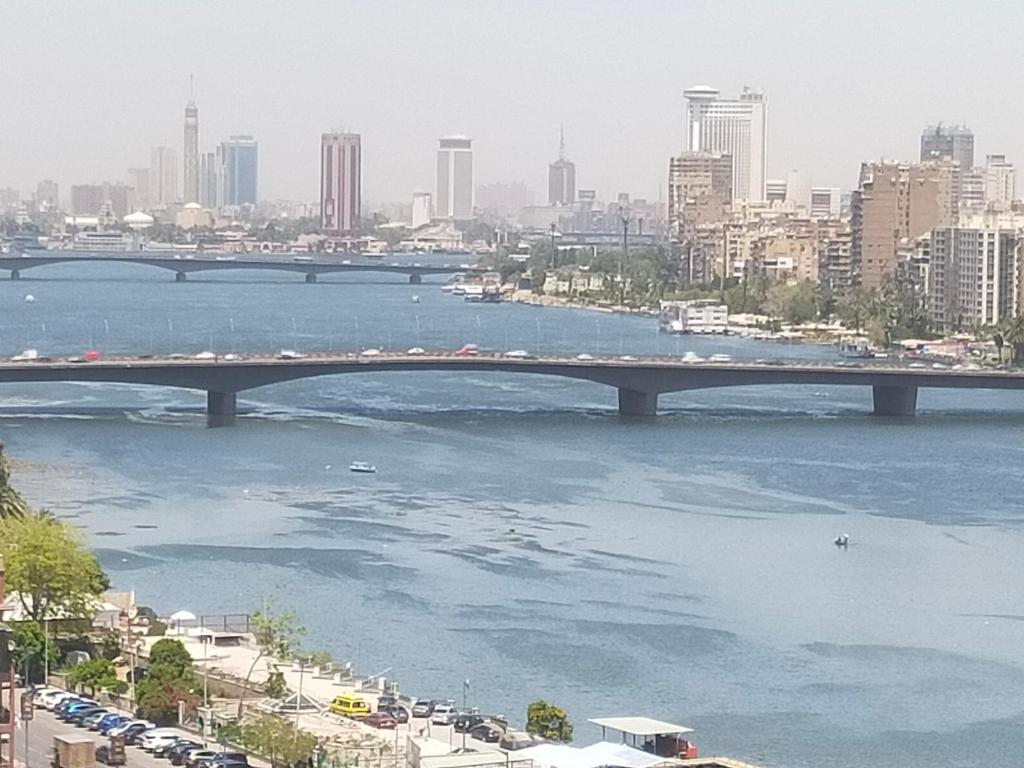 un puente sobre un río con una ciudad en el fondo en شقة فندقية فيو نيلي en El Cairo