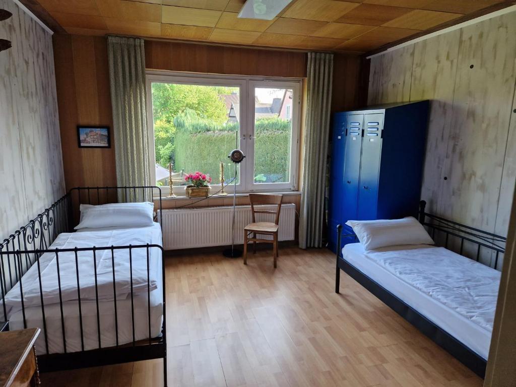 um quarto com duas camas e uma mesa e uma janela em Happy Place Indu Style em Korbach