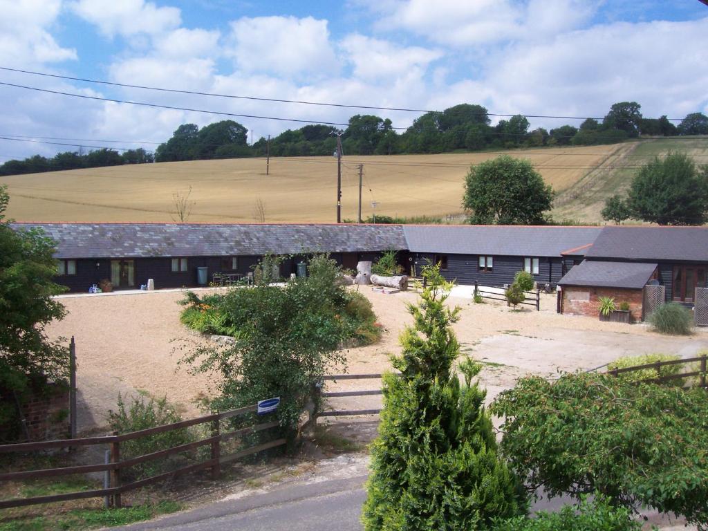 een gebouw met een hek voor een veld bij Five Cottages in AONB and a Hobbit House! in Canterbury