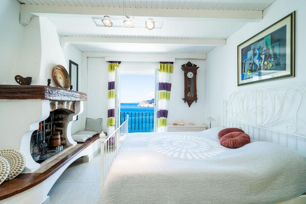 a bedroom with a white bed and a view of the ocean at Beach House Sveti Jakov 2 in Dubrovnik