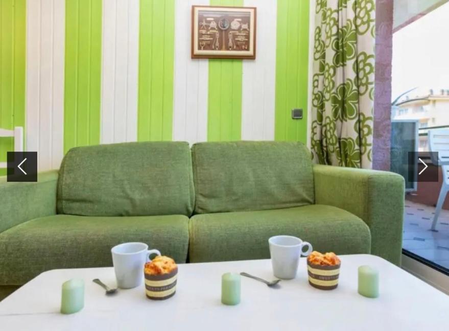 a living room with a green couch and a table at Apartamento familiar in Torroella de Montgrí
