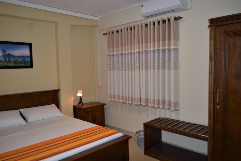 1 dormitorio con cama, mesa y ventana en Paramount Residence - 7 en Peliyagoda