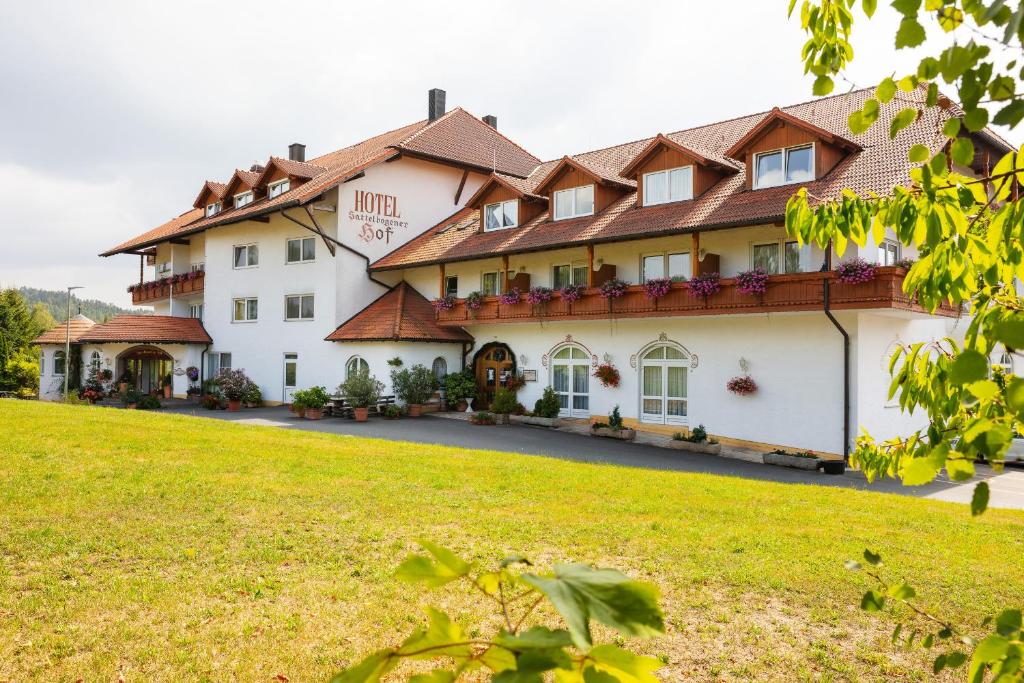 a large white building with a green field at Sattelbogener Hof in Traitsching