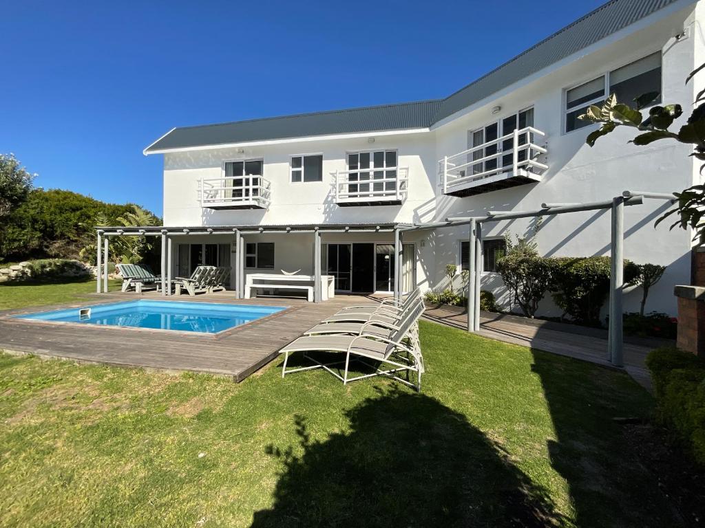 Casa blanca con piscina y sillas en Beach Break Guest Houses and Villas en Cape Saint Francis