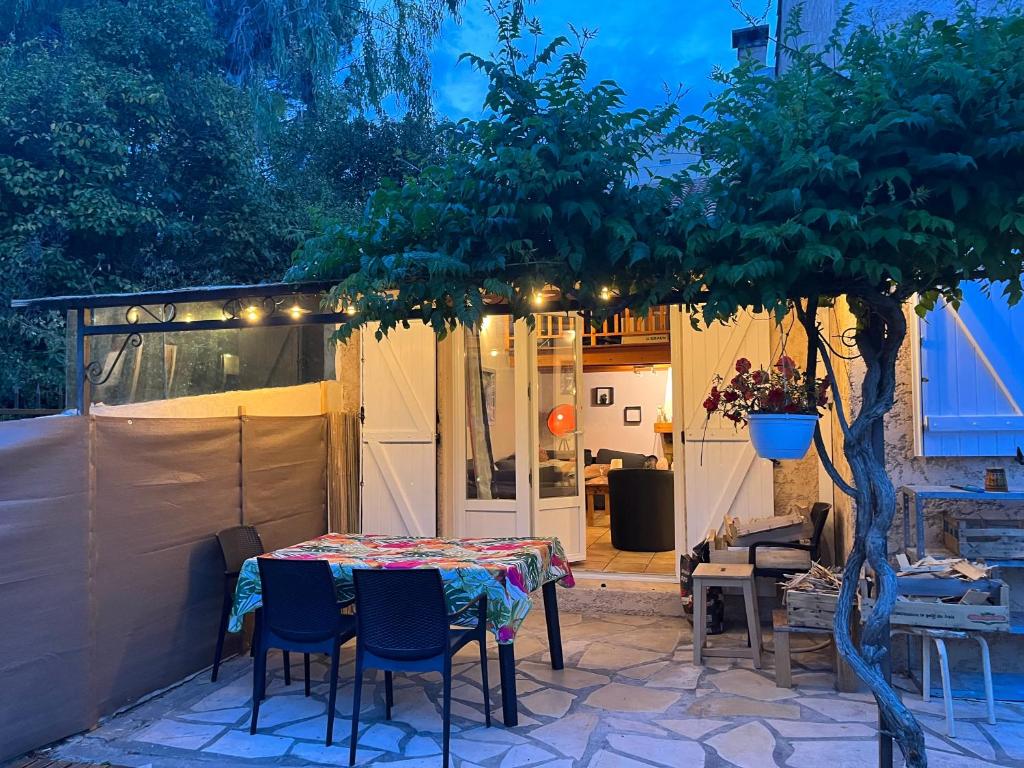 d'une terrasse avec une table, des chaises et un arbre. dans l'établissement Maison charmante idéale pour des vacances sur la côte d'Azur, à Antibes