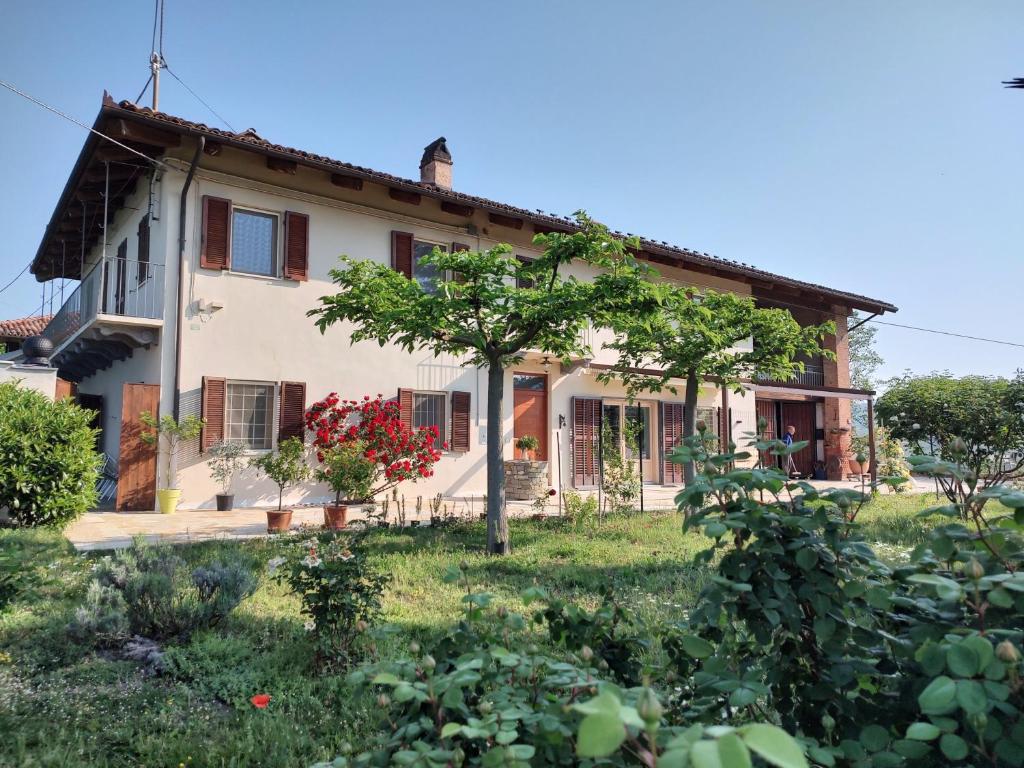 an old house with a tree in front of it at Riviera delle Langhe Wine Country House with a Pool in Monchiero