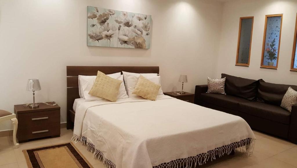 a bedroom with a large bed and a couch at White Pearl Apart 5 in Marsaxlokk