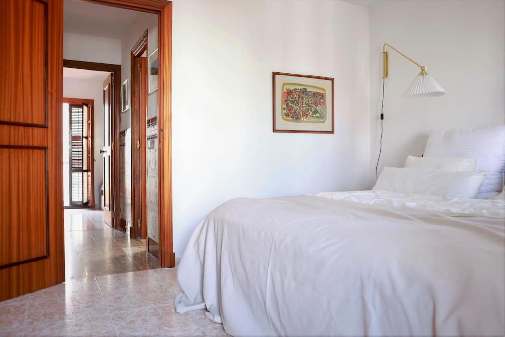 um quarto branco com uma cama branca e um corredor em Townhouse at the Beach em Estepona