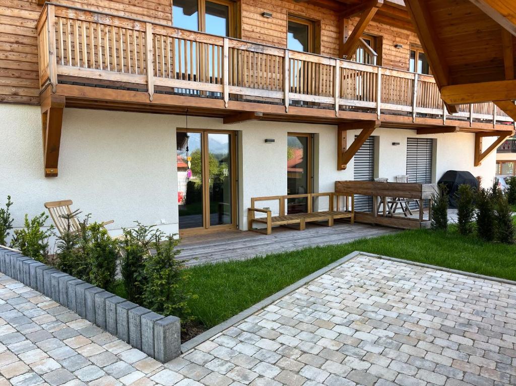 a house with a deck and a patio at Ferdis Lodge in Reit im Winkl