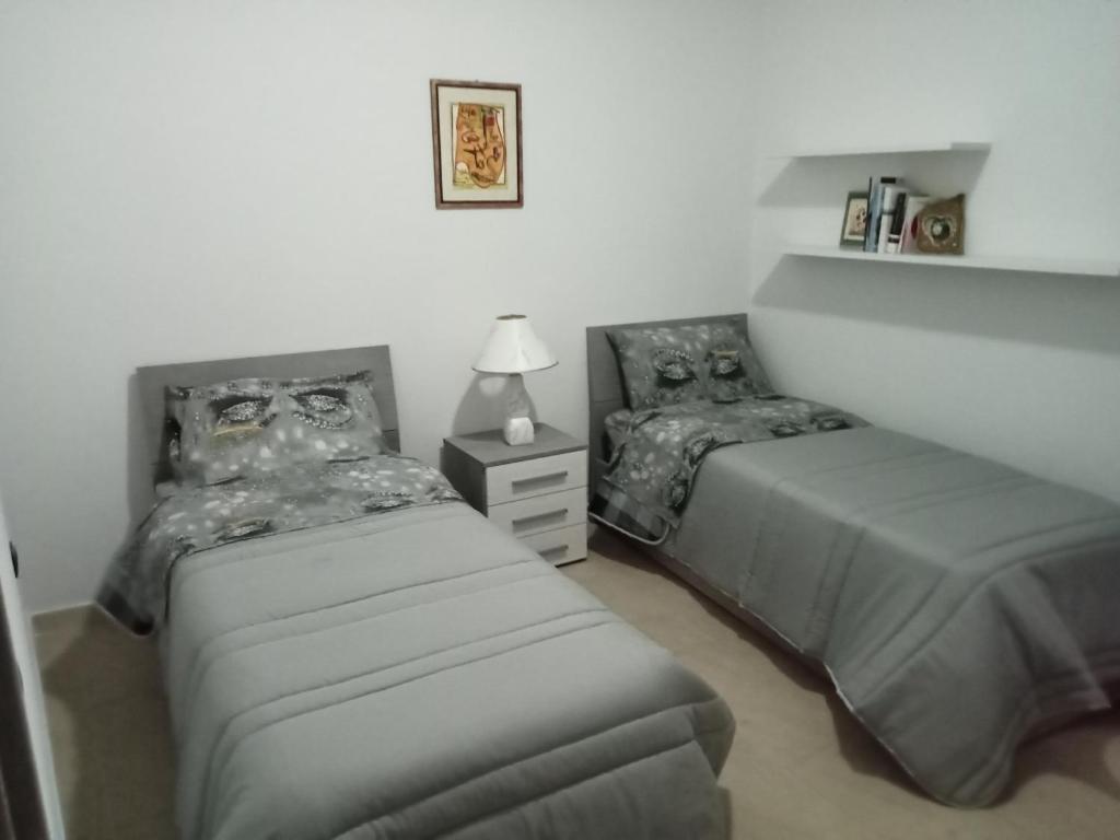um quarto com 2 camas e uma mesa de cabeceira com um candeeiro em Mont'Isoro em Orgosolo