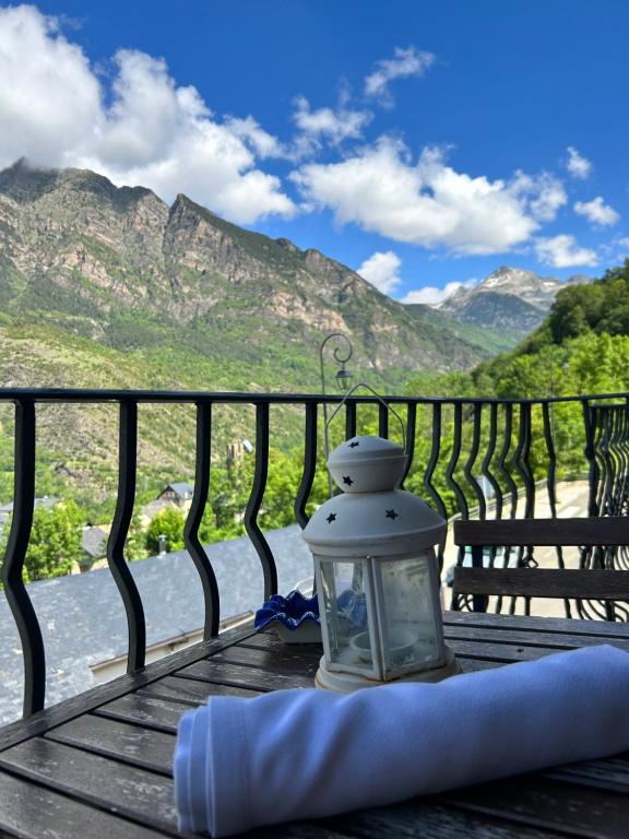 a lantern on a table with a view of the mountains at Apartaments Arenys De Boi in Bohí