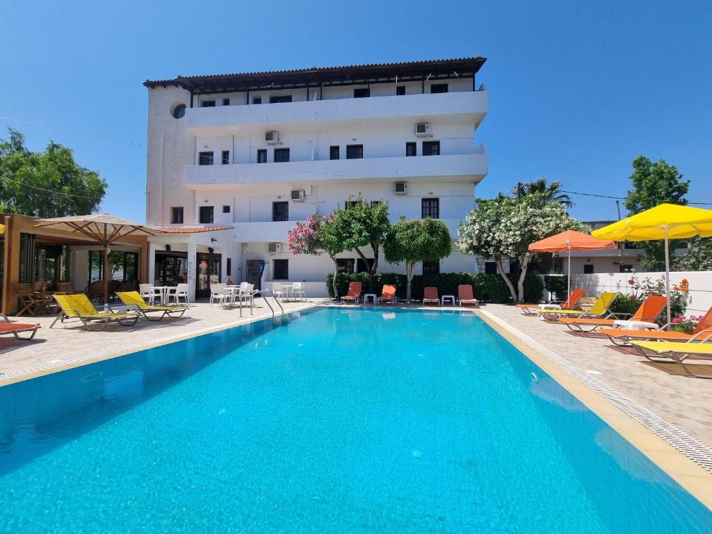 ein Hotel mit einem Pool vor einem Gebäude in der Unterkunft Arhodiko Hotel in Ammoudara