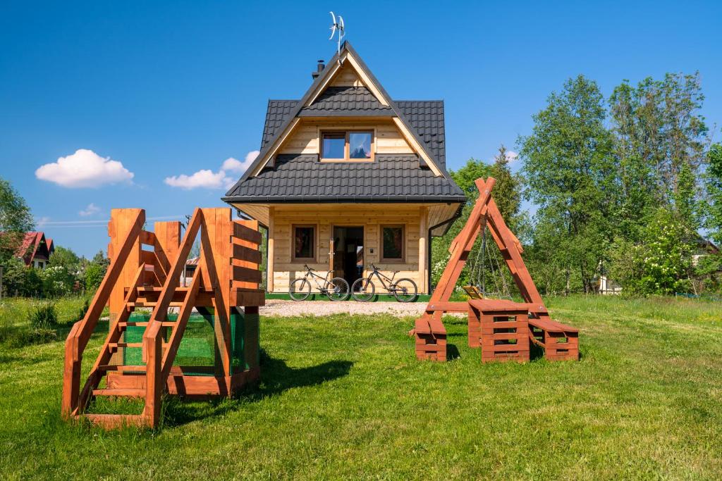 a small house with two wooden gates in front of it at Domek Z Widokiem Na Góry in Jurgów