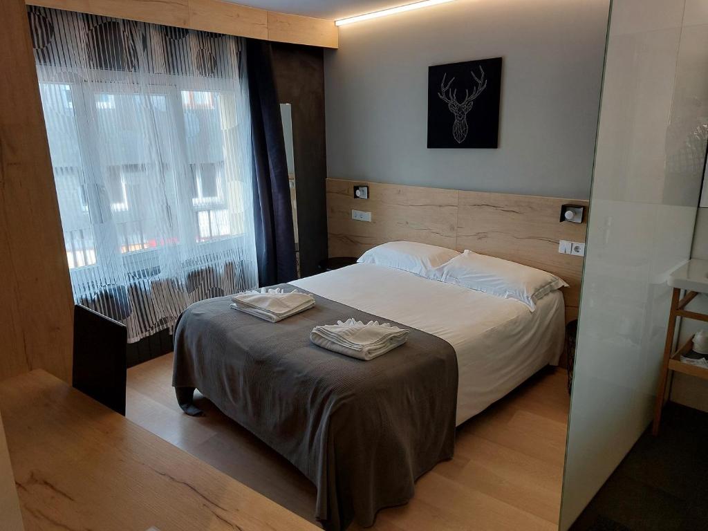 a bedroom with a bed with two towels on it at Hotel Mirtil in Pas de la Casa
