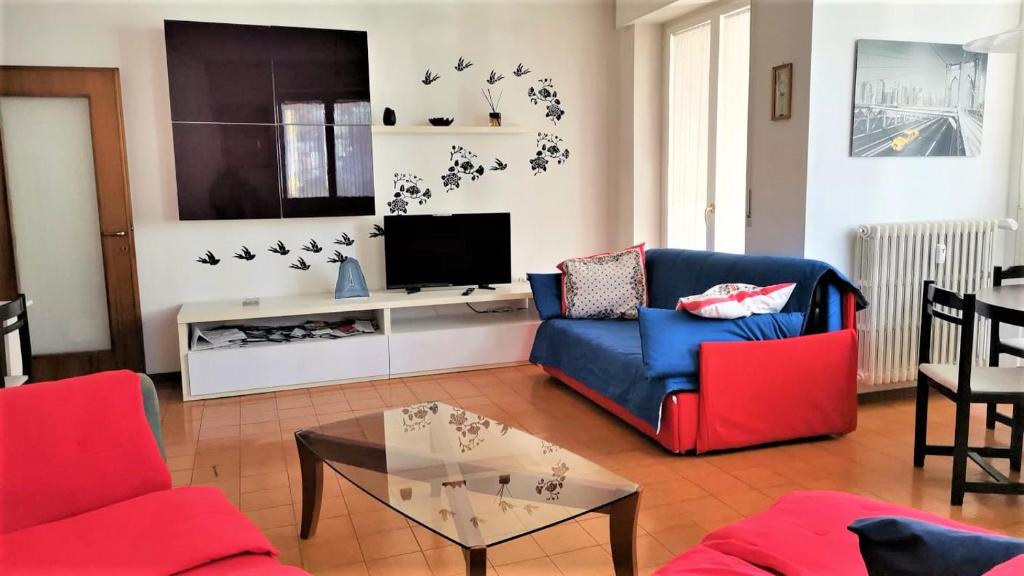 sala de estar con sofá azul y TV en SPAZIOSO APPARTAMENTO en Sondrio