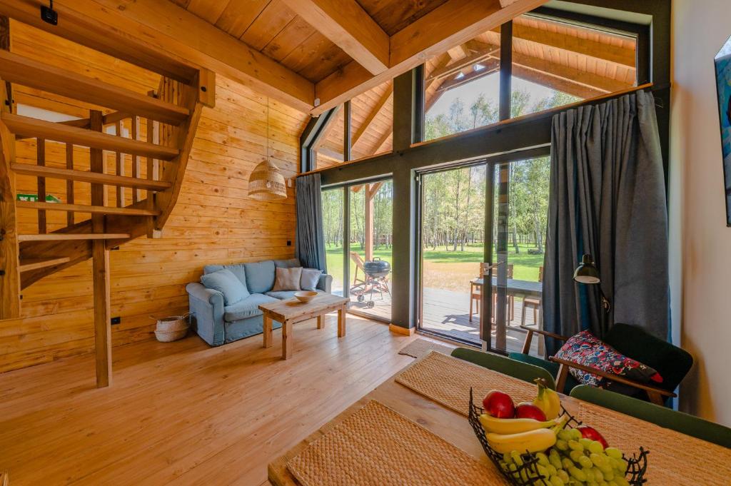 a living room with a couch and a table at Kaszuby - Komfortowe domki nad jeziorem in Barkocin