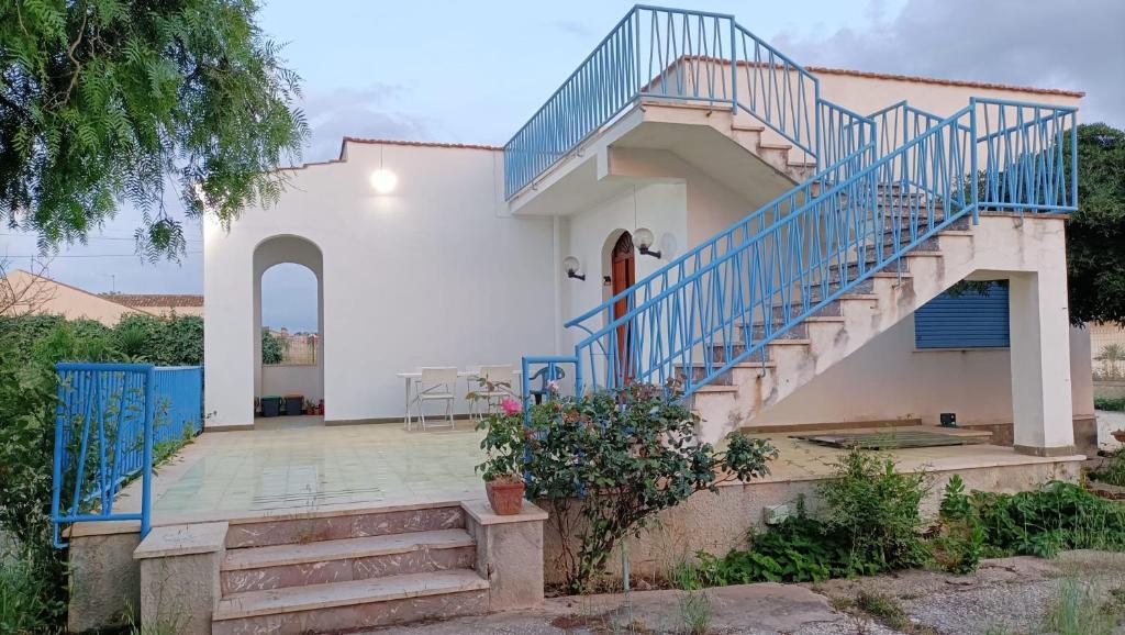Casa blanca con escalera con barandilla azul en Villa da Patty, en Marausa