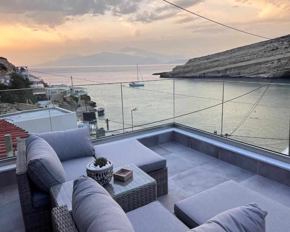 Aphrodite Luxury Accommodation في ماتالا: غرفة معيشة مع أريكة وإطلالة على المحيط