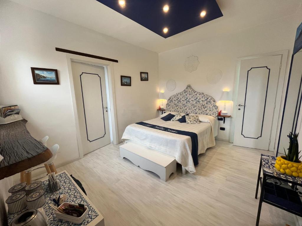 a large white bedroom with a bed and a table at Hill Valley View in Vico Equense