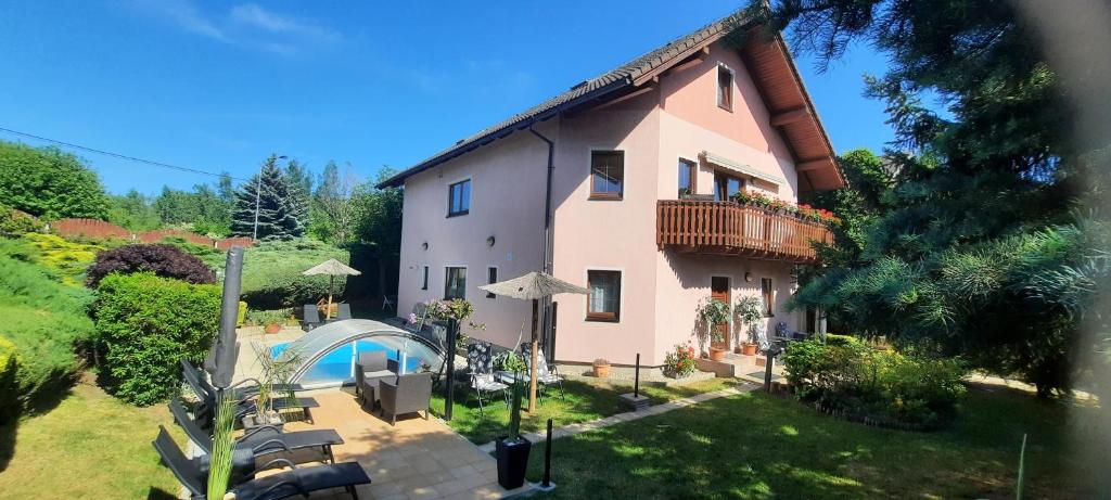 a large house with a balcony and a yard at Pool Apartments in Karlovy Vary