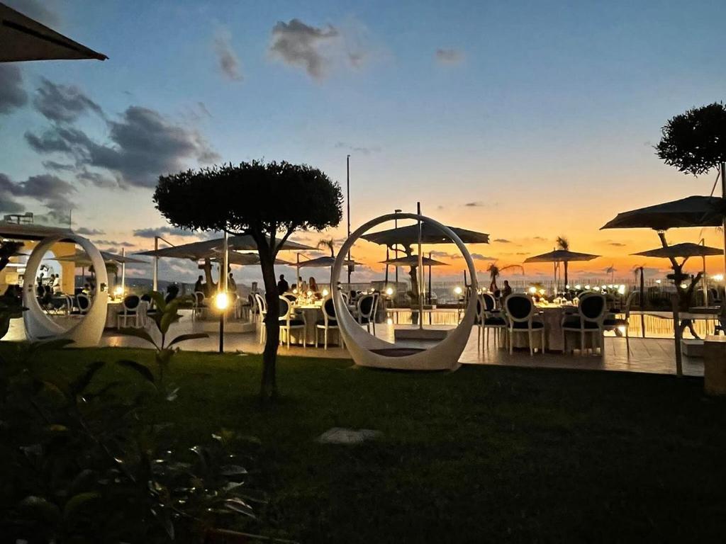 a sunset with tables and umbrellas in a park at Gal&igrave;a Luxury Resort in Pizzo