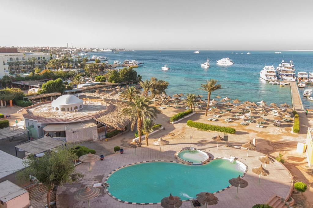 an aerial view of a resort with a swimming pool and the ocean at Dexon Roma Hotel in Hurghada