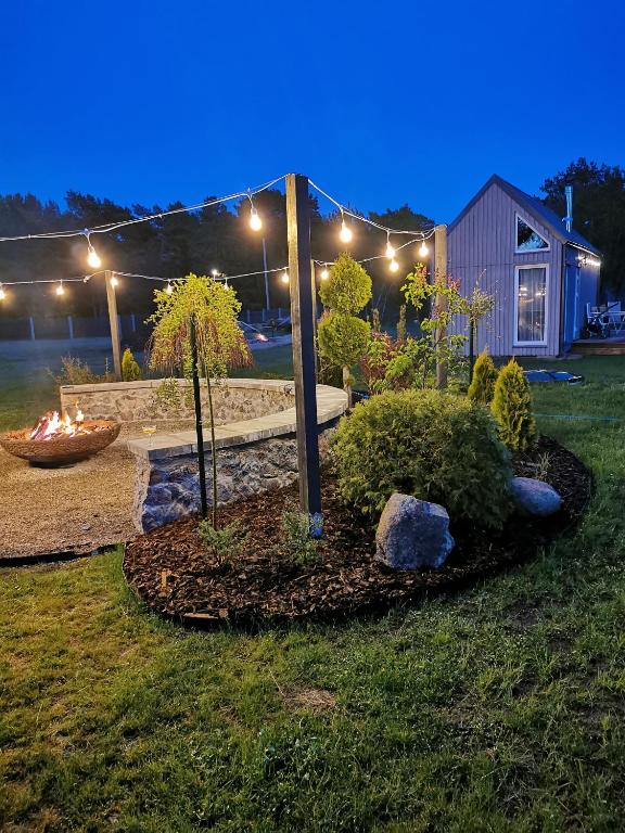 a garden with a fire place in the yard at night at Austrumi in Kolka