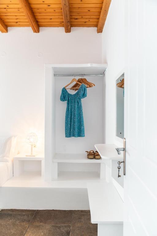 uma casa de banho branca com um vestido azul pendurado numa parede em Ta Kabia Studios em Rámos