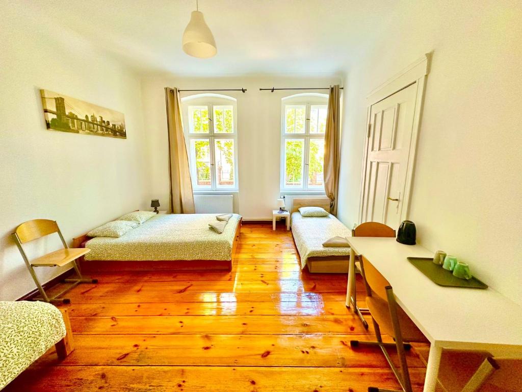 um quarto com duas camas e uma mesa em Atlas' House em Poznań