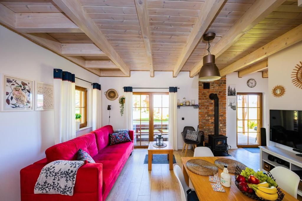 a living room with a red couch and a table at DOMEK LUKSUSOWY KASZUBSKA OSTOJA in Barkocin