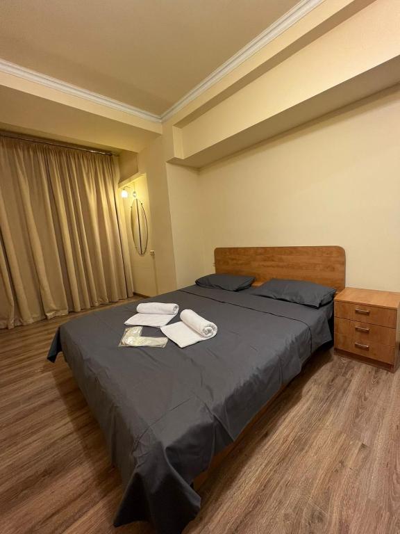 a bedroom with a bed with two towels on it at Nice Apartment In Yerevan on Sayat Nova Sreet in Yerevan