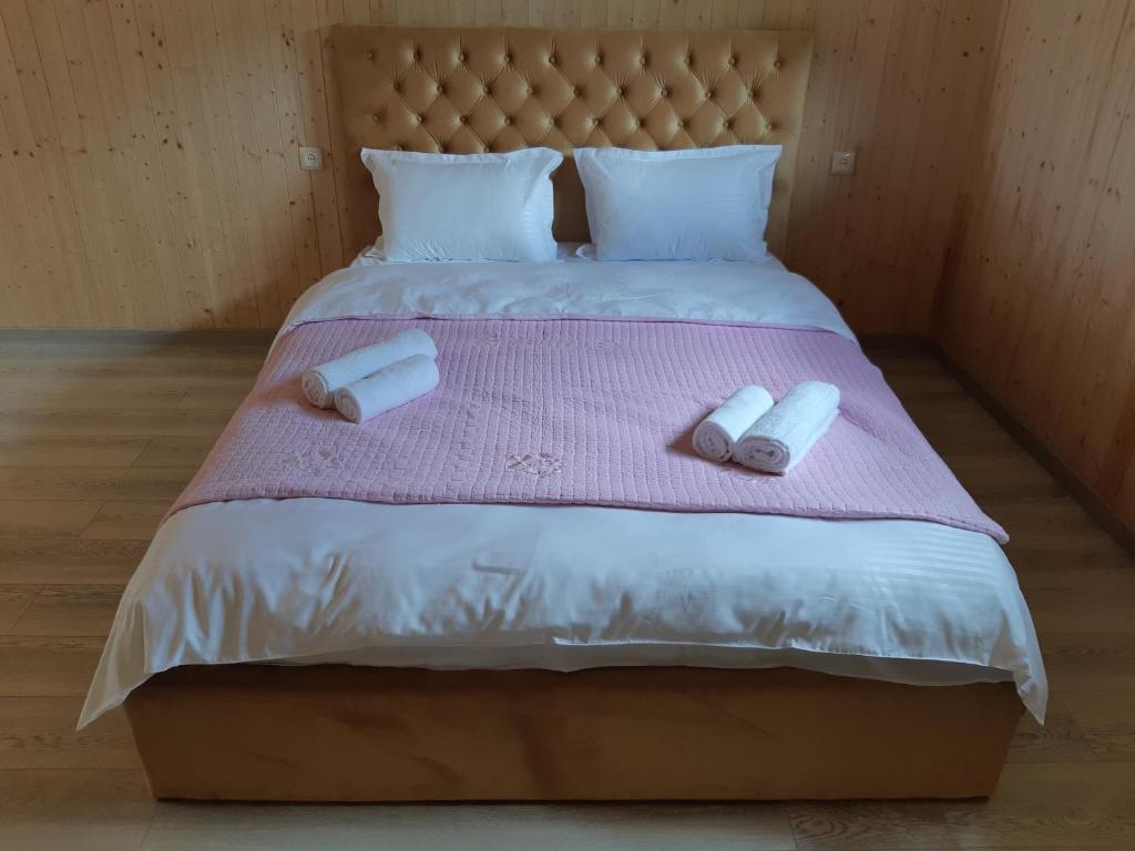 Arsha的住宿－Elegia，一张带两条毛巾的床铺,放在粉红色的毯子上