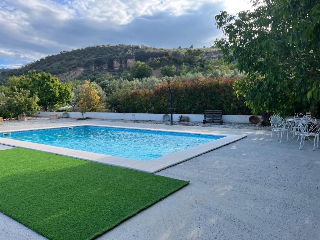 a swimming pool with a green lawn around it at Casa Rural Sabika in Alhama de Granada