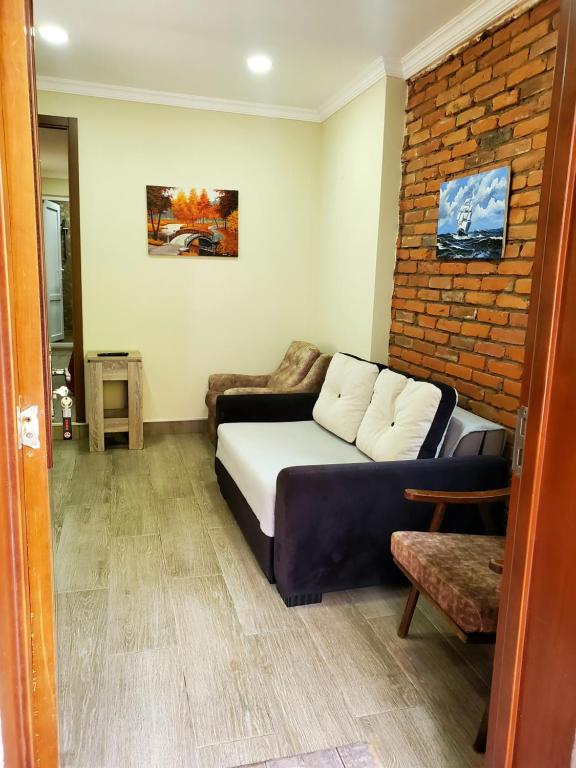 sala de estar con sofá y pared de ladrillo en Guest house Agmashenebeli 229 en Kobuleti