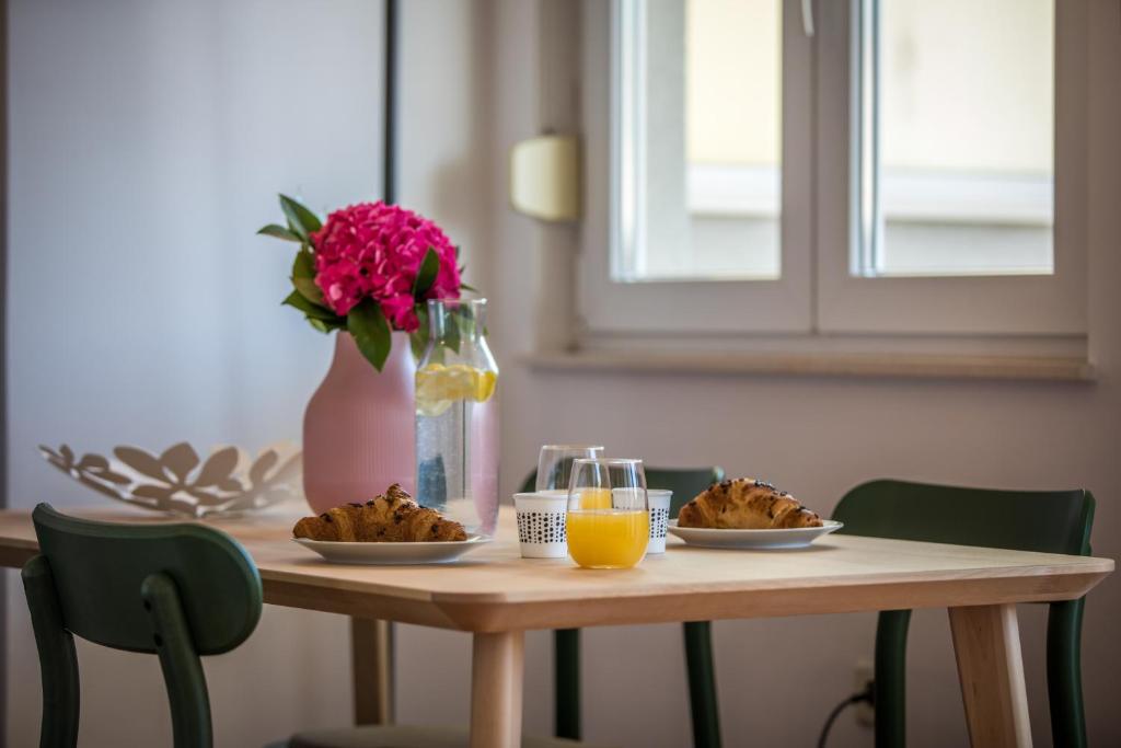 een tafel met borden en een vaas met bloemen bij Apartment Lapad in Dubrovnik