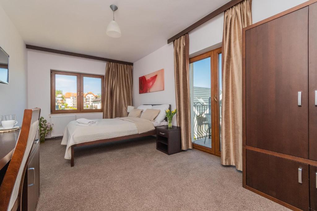 a bedroom with a bed and a balcony at Baltik Park in Krynica Morska