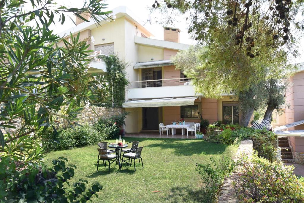 a garden with a table and chairs in front of a house at Villa Julia in Sani Beach