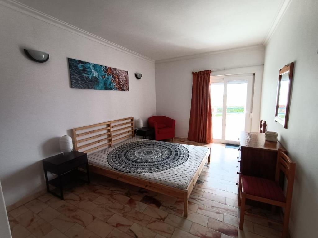 een slaapkamer met een bed, een bureau en een raam bij Oura Li in Albufeira