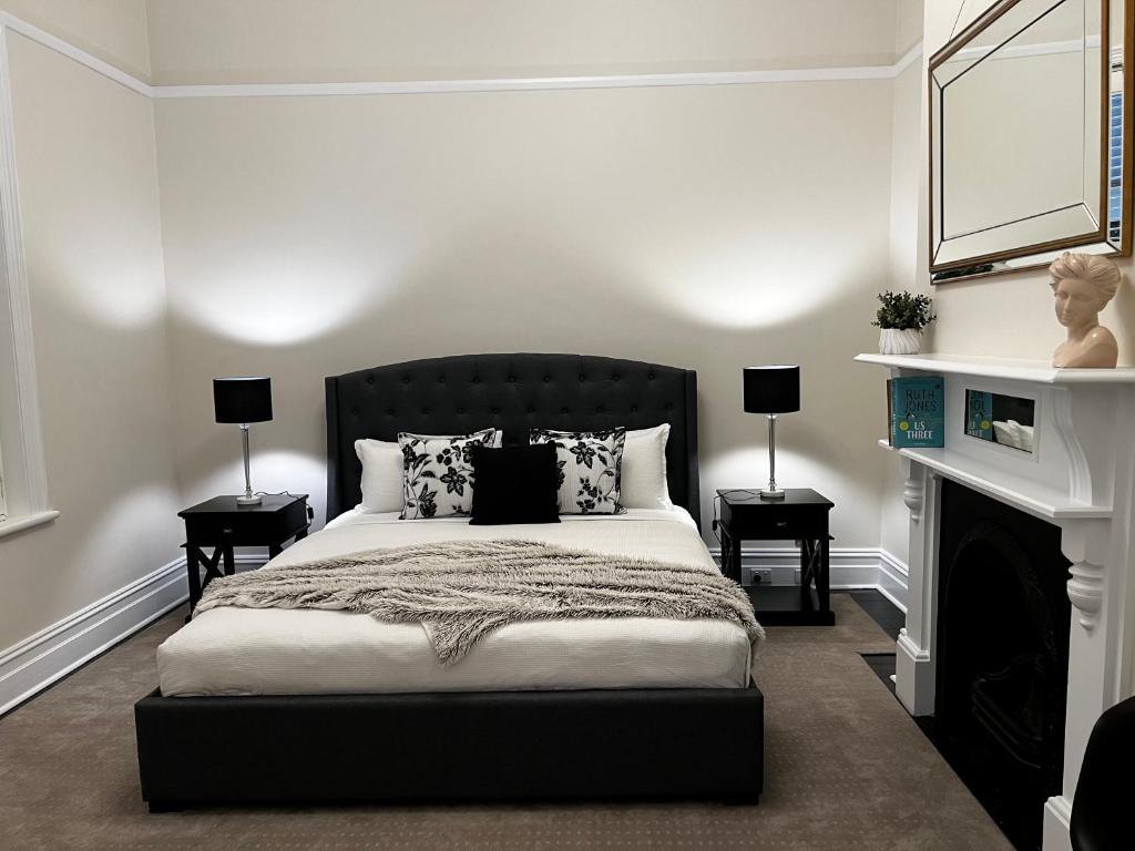 a bedroom with a bed and a fireplace at Villa on Melbourne St in Adelaide