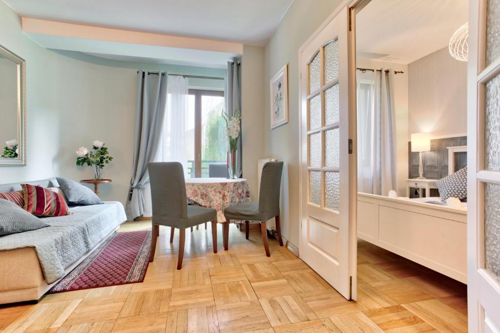 ein Wohnzimmer mit einem Tisch, Stühlen und einem Sofa in der Unterkunft Tyzenhauz Apartments Lobzowska Street in Krakau