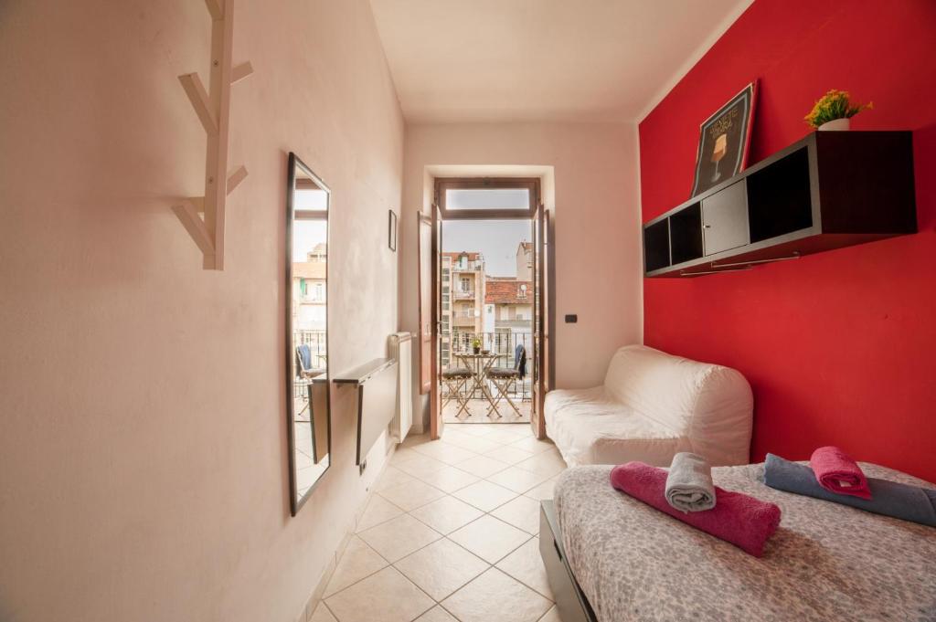 a room with two beds and a red wall at Cozy ROOM STANZA close city center in a family House Stanza in appartamento condiviso noi viviamo in casa STANZA in affitto in Turin